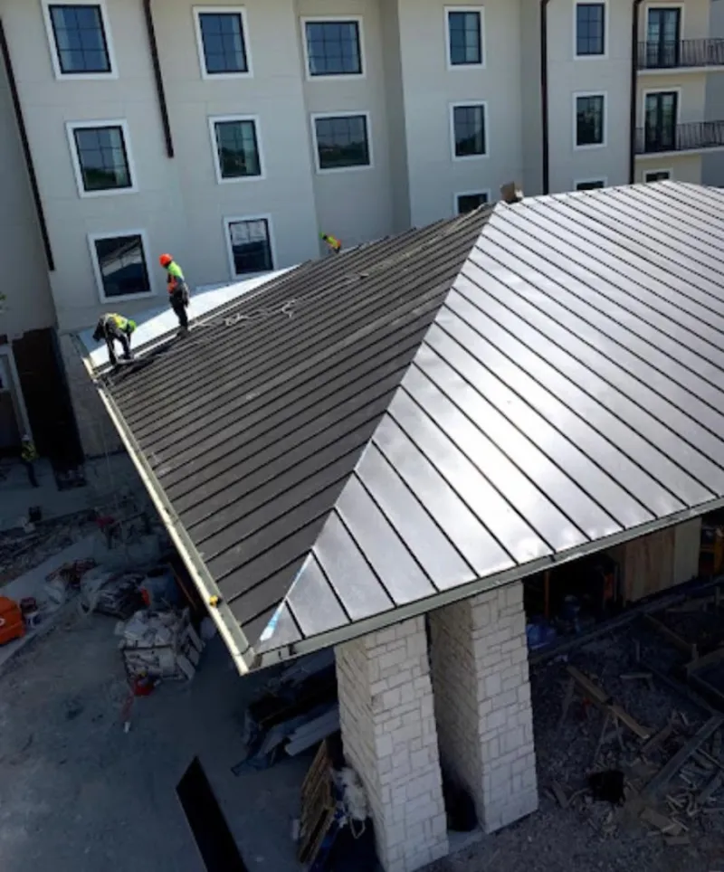 Crew installing standing seam metal roof panels on a commercial project in Altamonte Springs